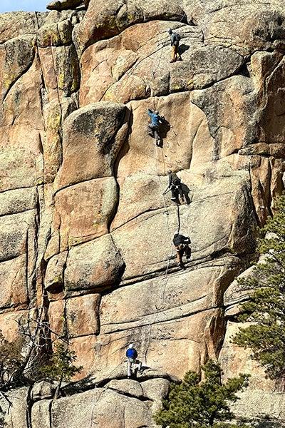 Climbers scaling a vertical via ferrata section